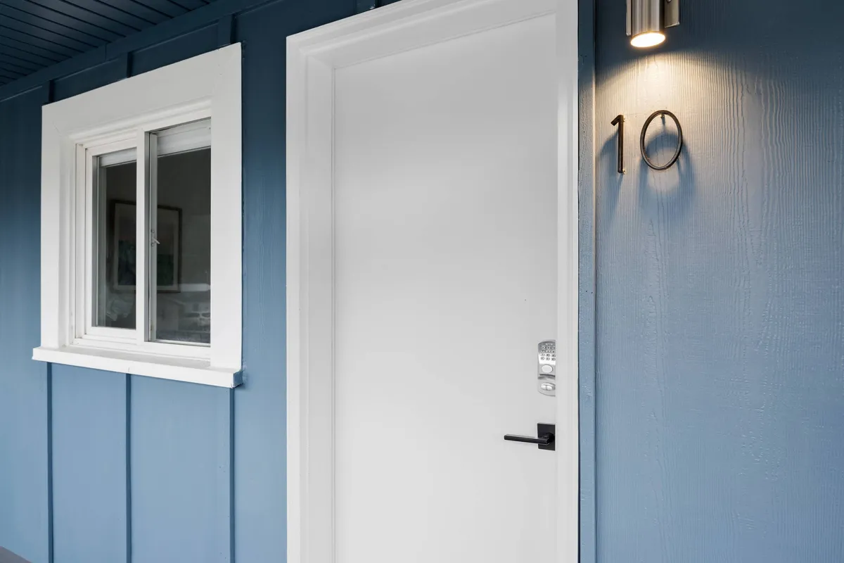 A bright and inviting entryway with a white door labeled with the number 10 and a window beside it. The scene captures the welcoming first impression guests and their pets will experience on arrival.
